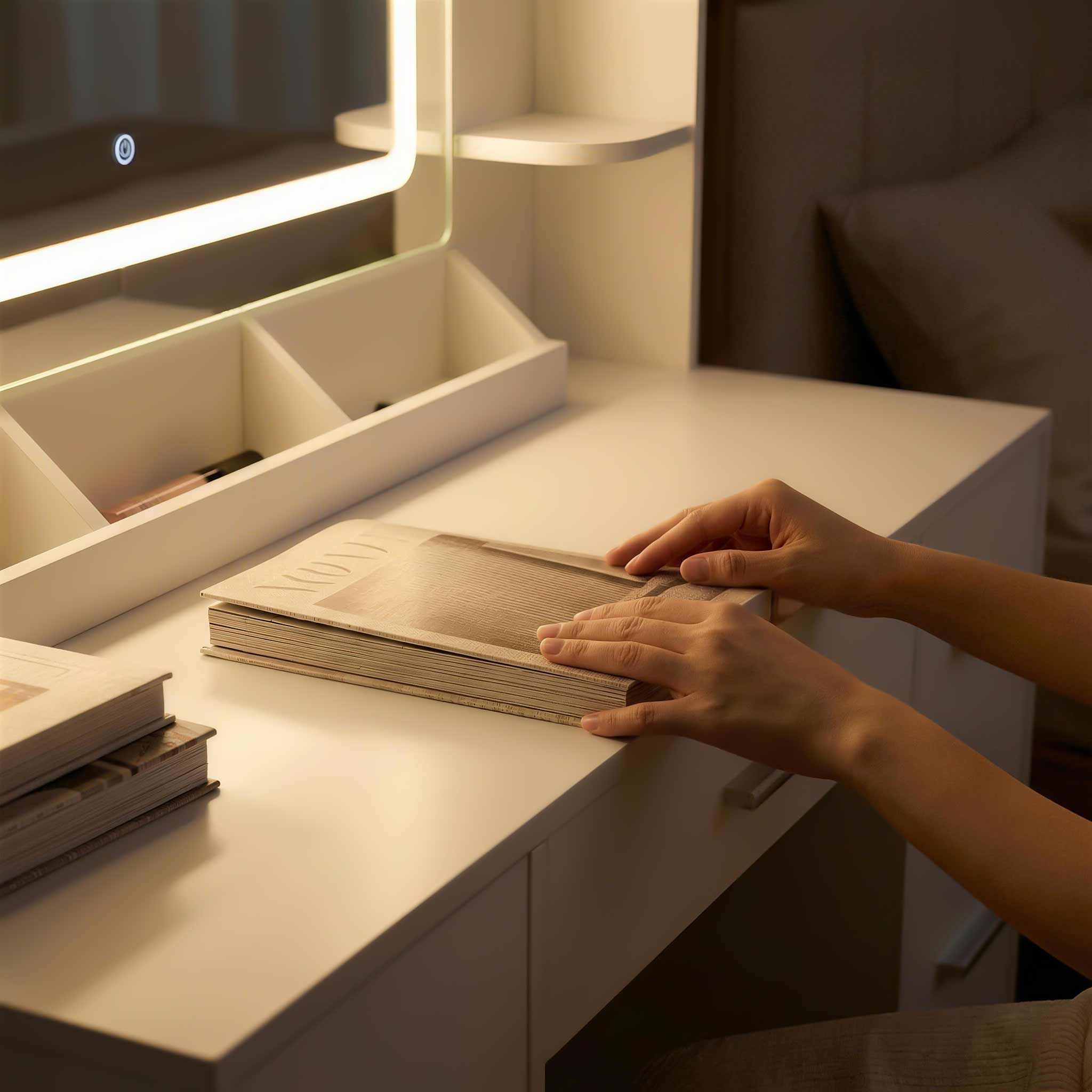 Close-up of hands reading a book at a Treevan vanity desk illuminated by warm LED mirror lighting for a relaxing atmosphere.